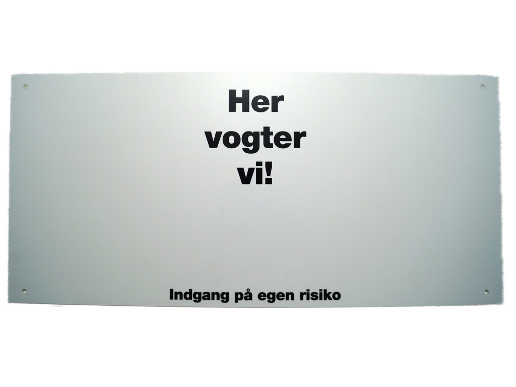 Skilt Her Vogter Vi hvid 43x20cm